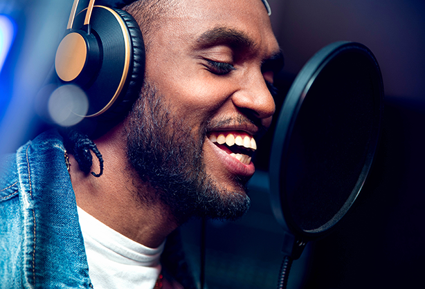 Image of an R&B singer recording a song in a music studio.